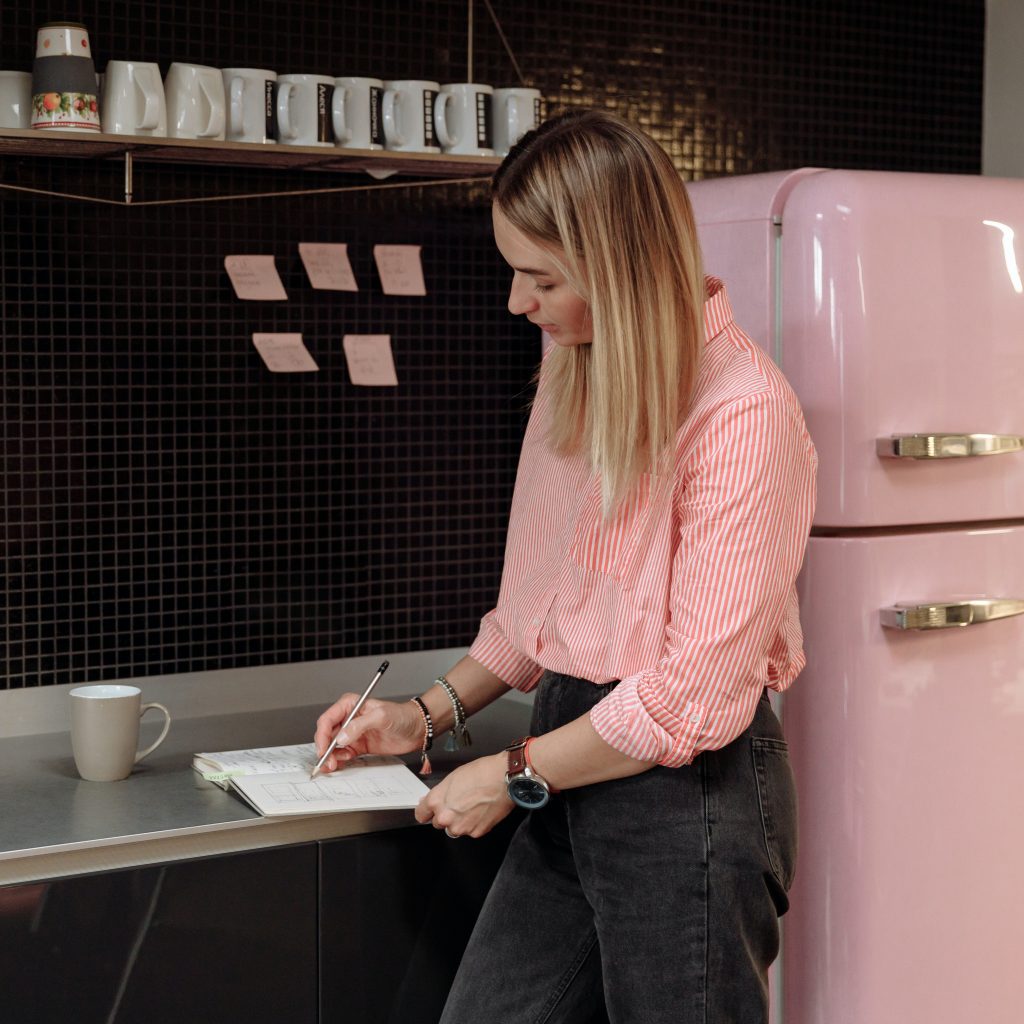 freelance graphic designer next to pink fridge