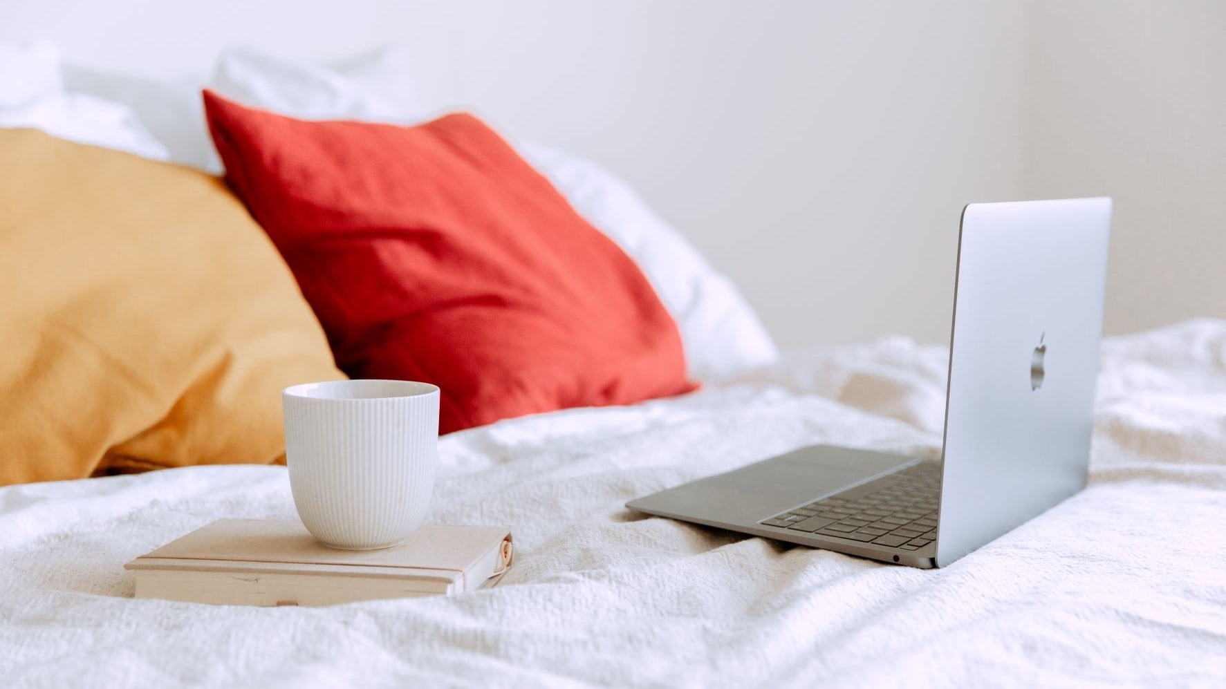 laptop on a white bed