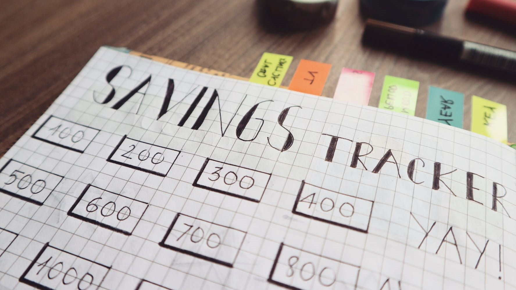 design business savings tracker in a notebook