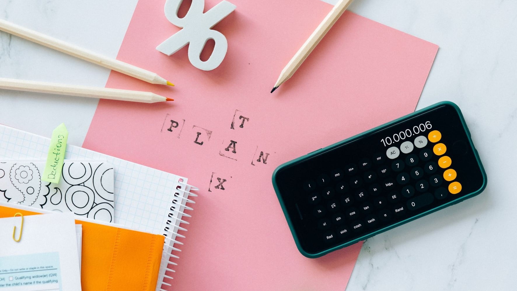 calculator and pink paper that says tax plan