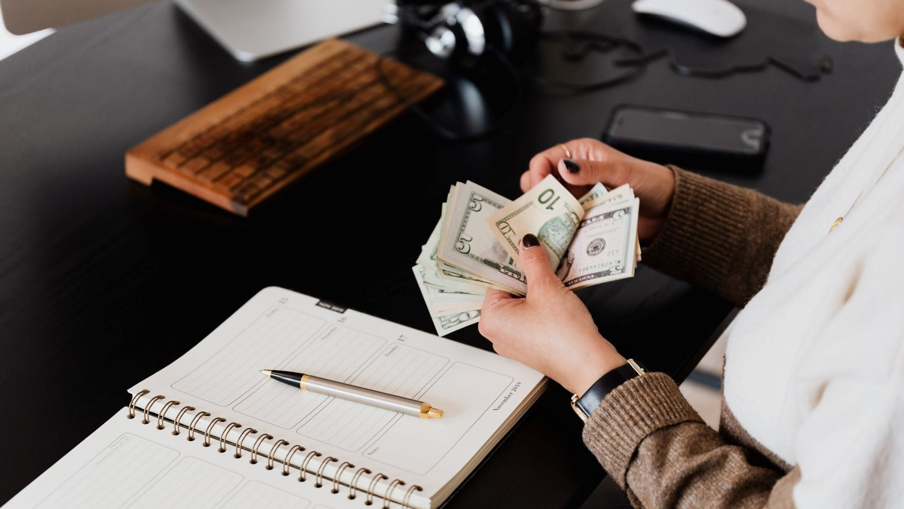 web designer counting money at her desk
