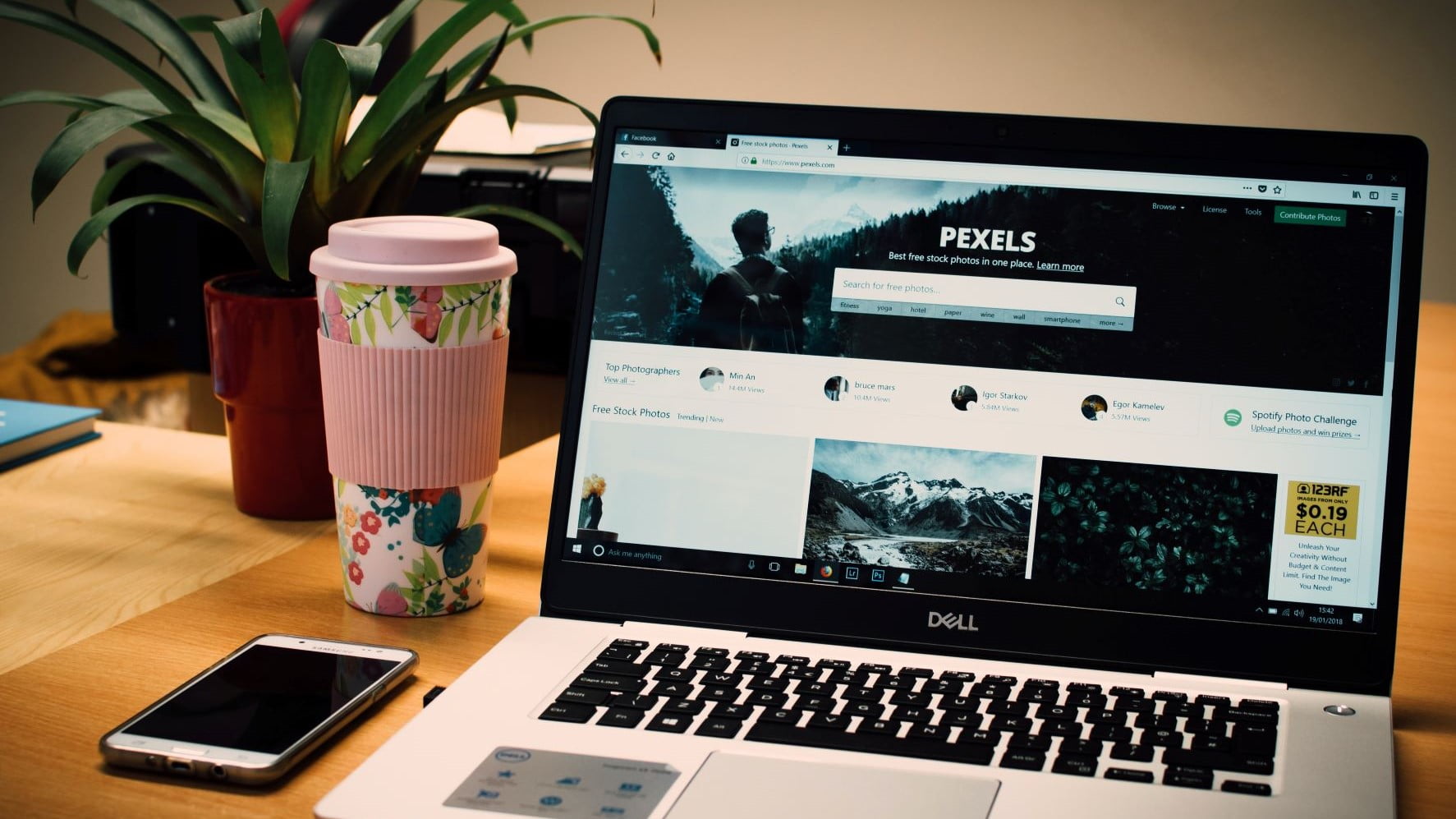 pink coffee cup next to laptop