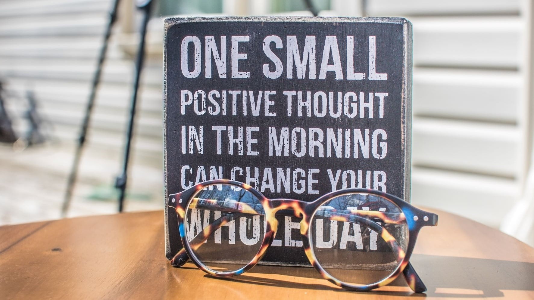 glasses in front of a sign with a positive affirmation
